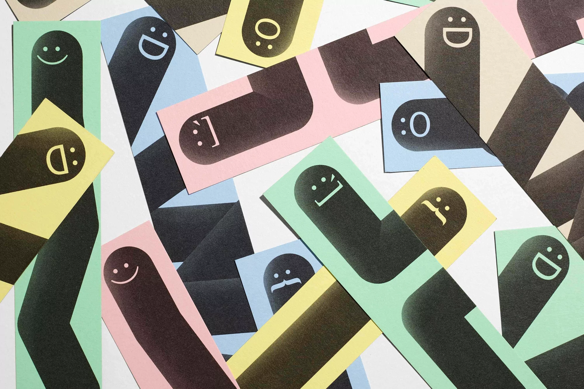 Graphic paper art with emoticon faces on colorful rectangles scattered on white surface. Paper art, emoticons, graphic design concept.