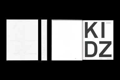 Book design featuring minimalist white embossed cover and bold black typographic layout against a black background