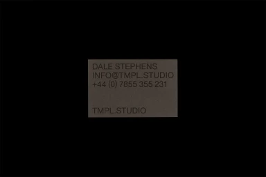 Minimalist dark business card design for TMPL featuring clean typography and contact details on a textured paper background.