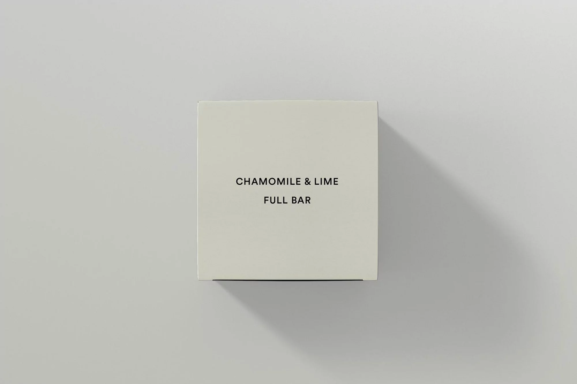 Overhead shot of a square box with the words 'Chamomile & Lime, Full Bar' in black lettering on an off-white background.