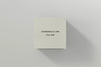 Minimalist square product box with black typography centered on a light grey background casting a sharp diagonal shadow