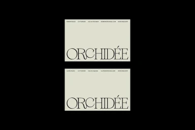 Two cream-colored business cards with black typography displayed centrally against a solid black background.
