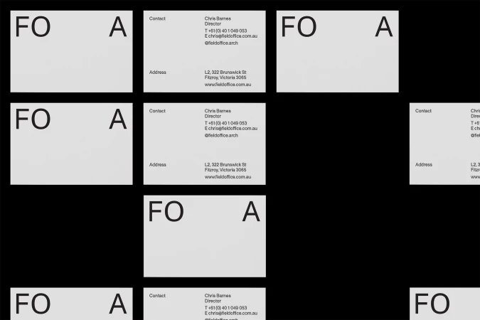 Collection of business cards on a dark background, featuring company logo, contact information, and street address in a minimalist design.