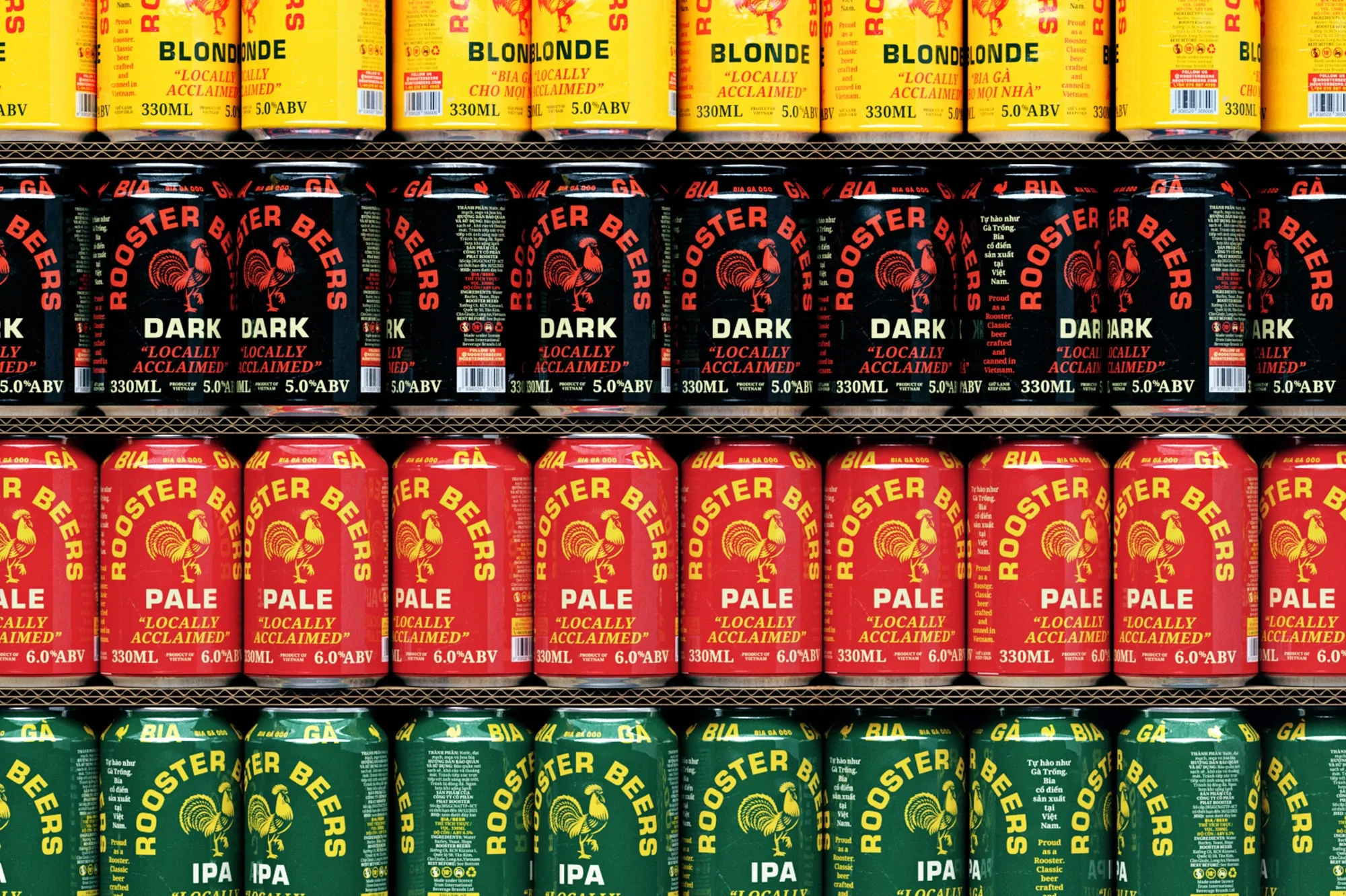 Stacked rows of colourful Rooster Beers aluminium cans in yellow, black, red, and green against a structured background.