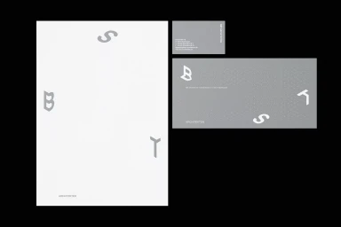 Minimalist brand identity stationery featuring grey typography and geometric architectural lettering on white paper.