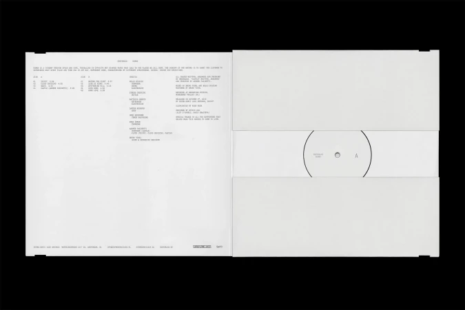 Open white vinyl record packaging featuring album information on the left and the vinyl record on the right, set against black backdrop.