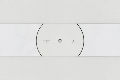 Minimalist graphic design featuring a white vinyl record label with clean typography and a side indicator letter A.