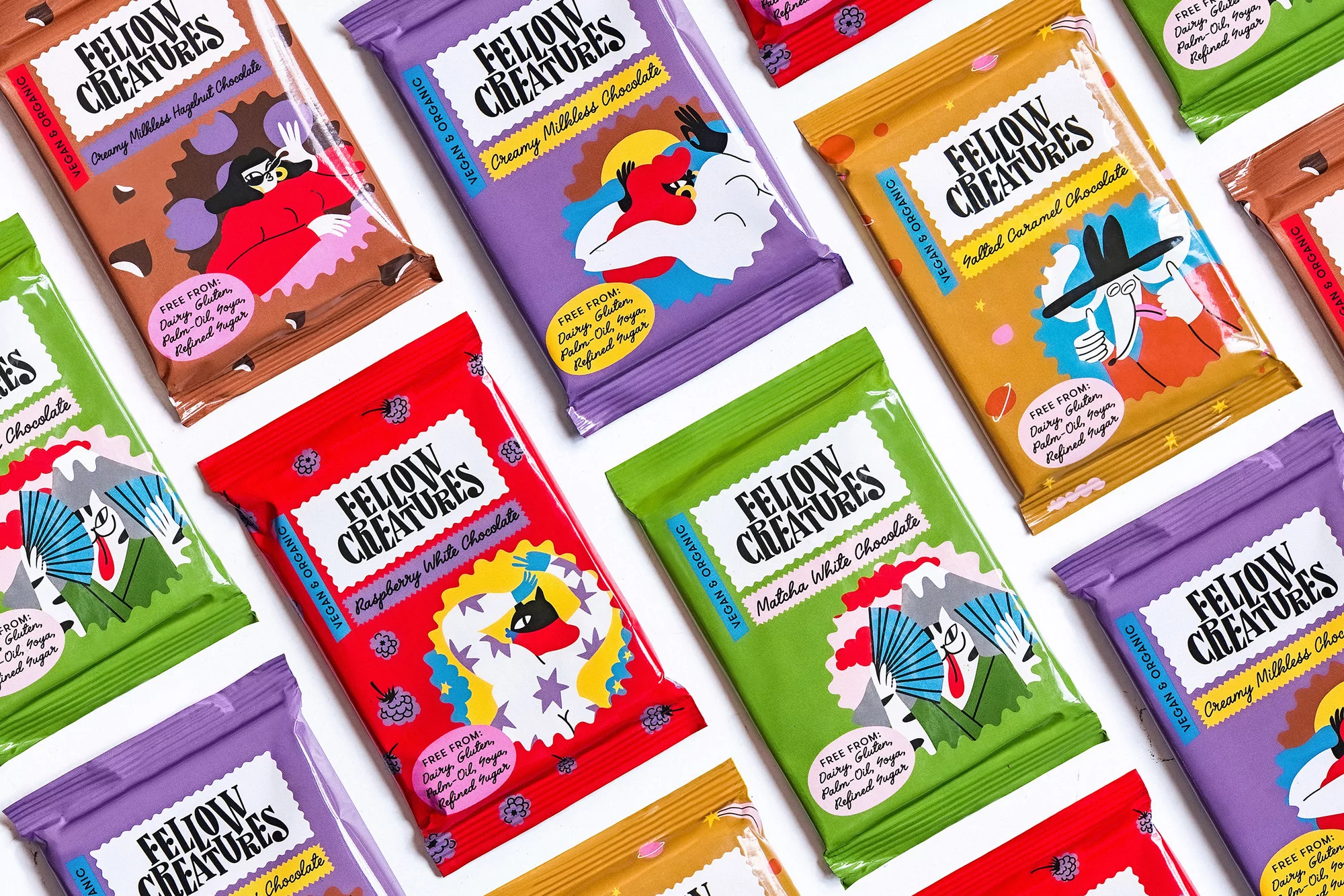 Assortment of colorful chocolate bars from Fellow Creatures, a vegan and organic brand, displayed on a white surface.