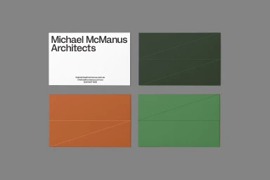Four rectangular business cards displayed on a solid grey surface featuring typography and geometric diagonal lines.