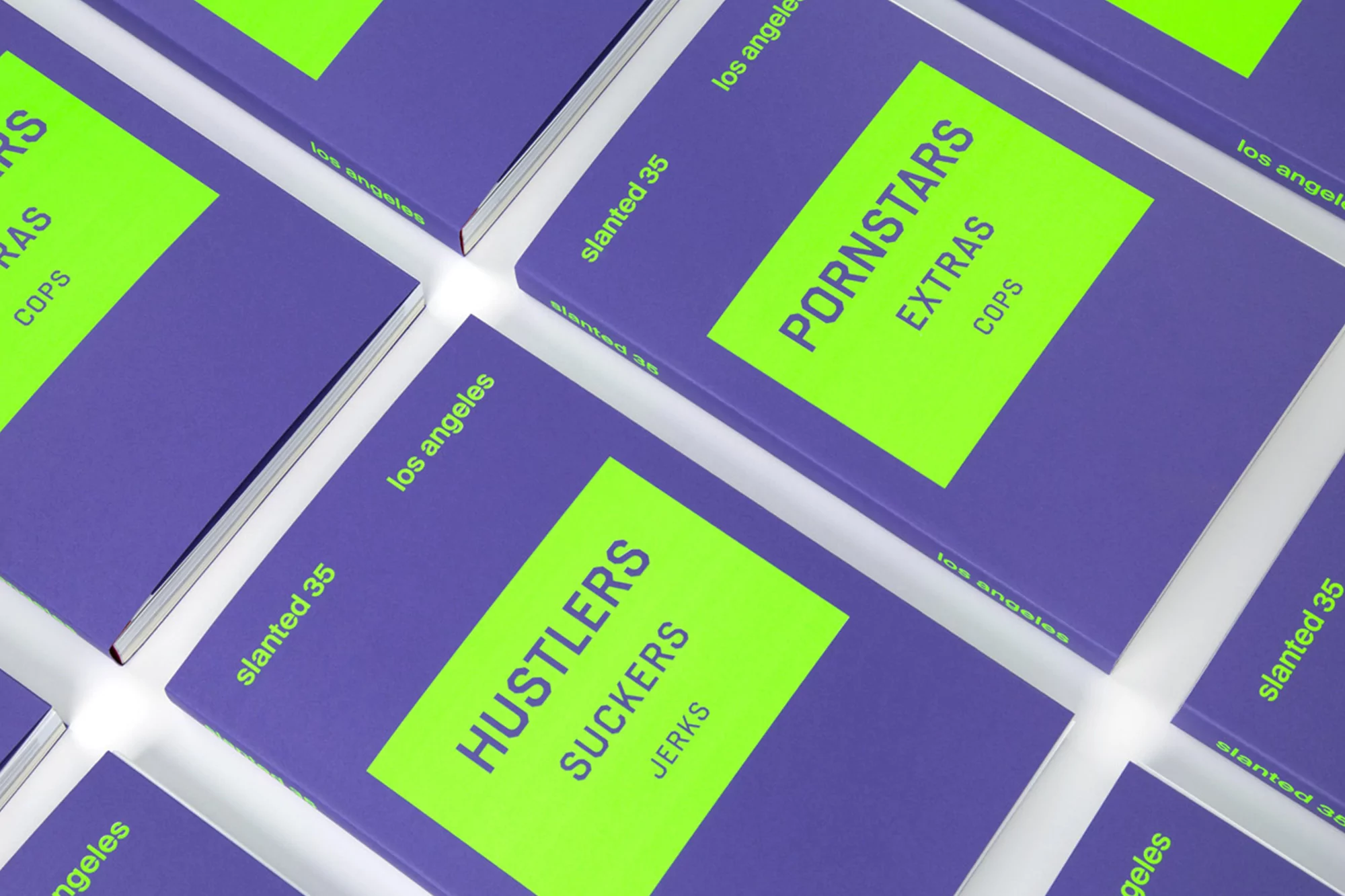 A grid arrangement of books, predominantly purple with neon green accents, showcases various titles and words, creating an editorial style.