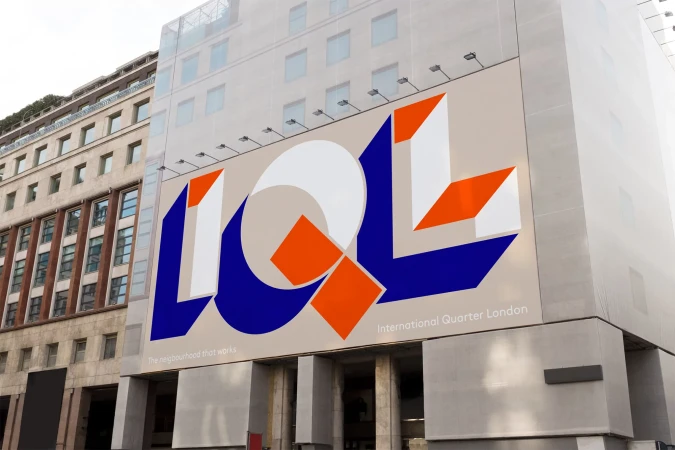 Building facade with large artistic geometric billboard featuring blue, white, and orange shapes, promoting International Quarter London.