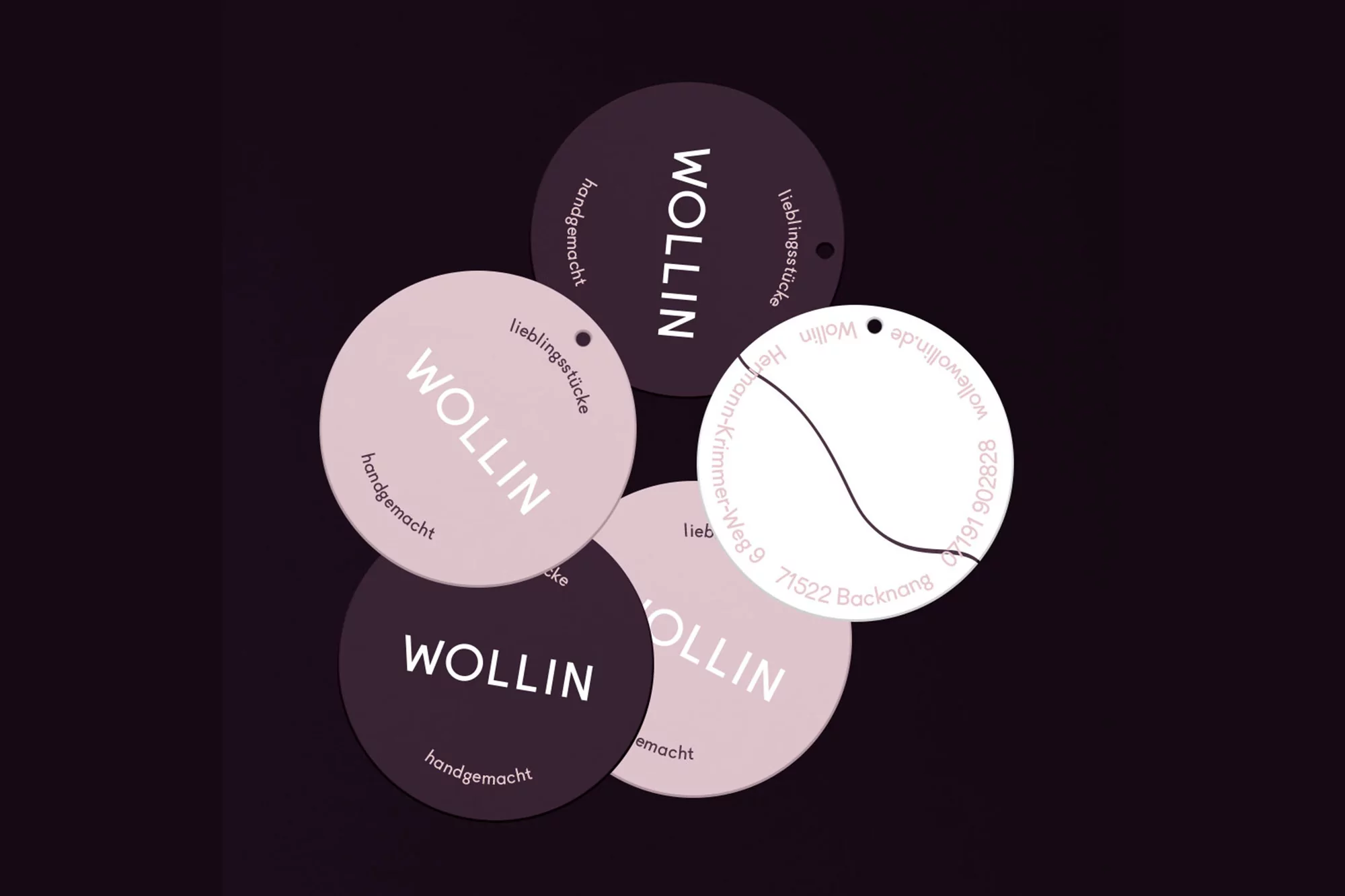 Several round tags with the word WOLLIN and the phrase 'handgemacht' are arranged against a dark purple background.