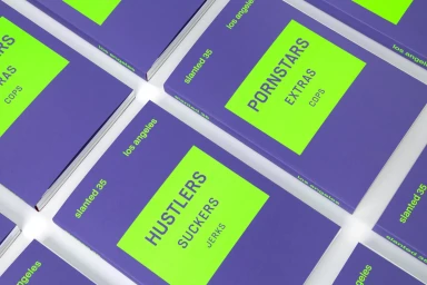 Multiple purple and neon green softcover books arranged diagonally on a clean white surface.