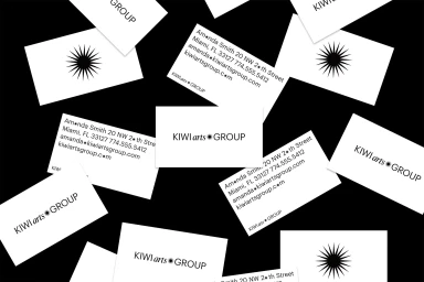 Scattered white business cards featuring black typographic logos and sunburst icons against a dark black background.