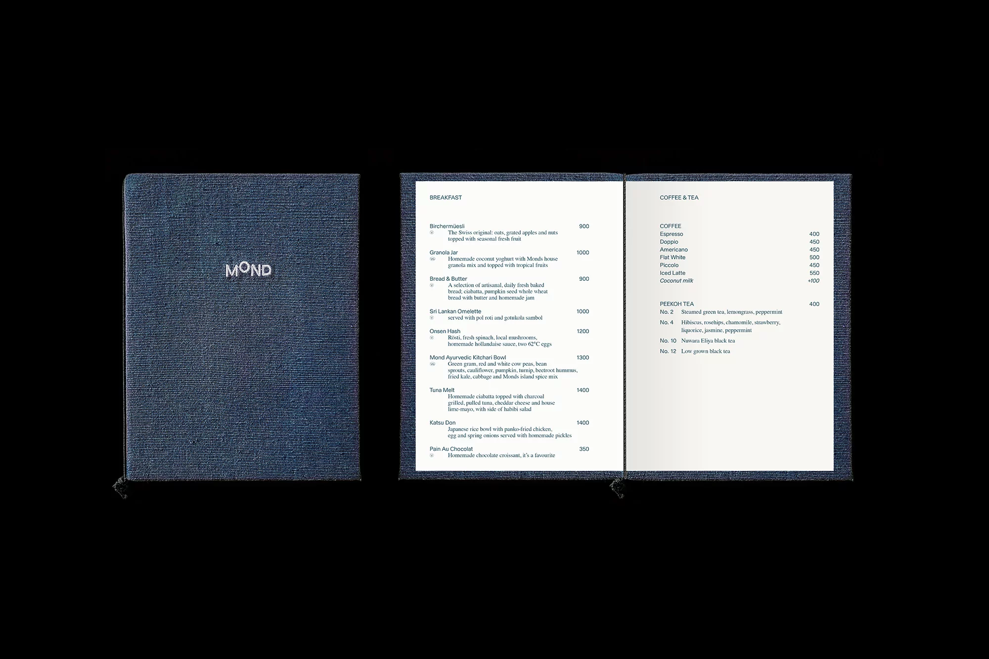 Close-up of a textured blue menu with white text 'Mond' next to an open menu displaying breakfast, coffee and tea selections.