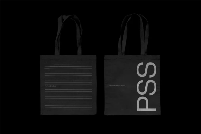 Two black tote bags are positioned against a black background, featuring text and simple line designs in white, creating a minimalist look.