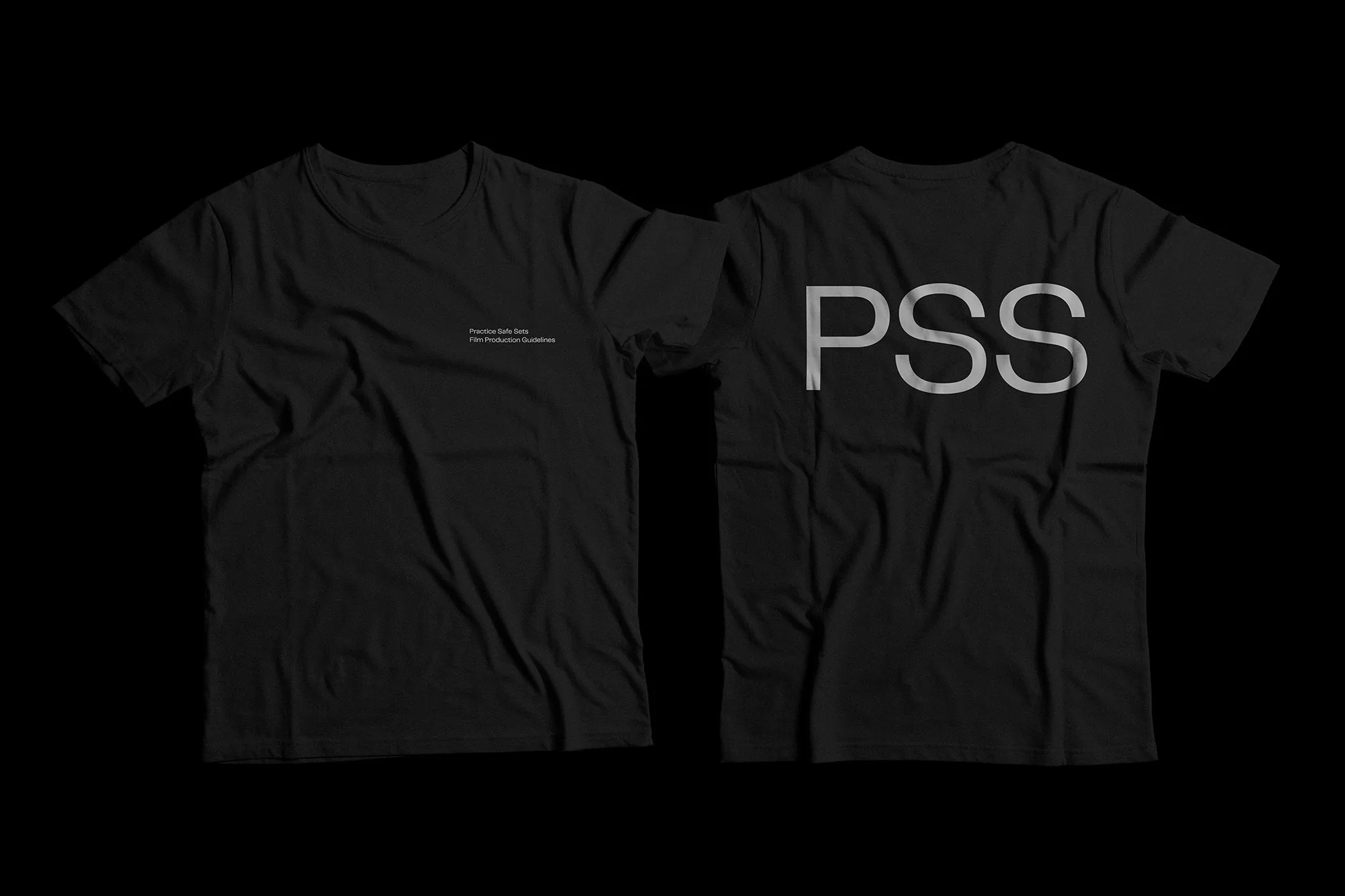 Two black t-shirts, one with small text on the front and the other with large white 'PSS' text on the back, are displayed on a black background.