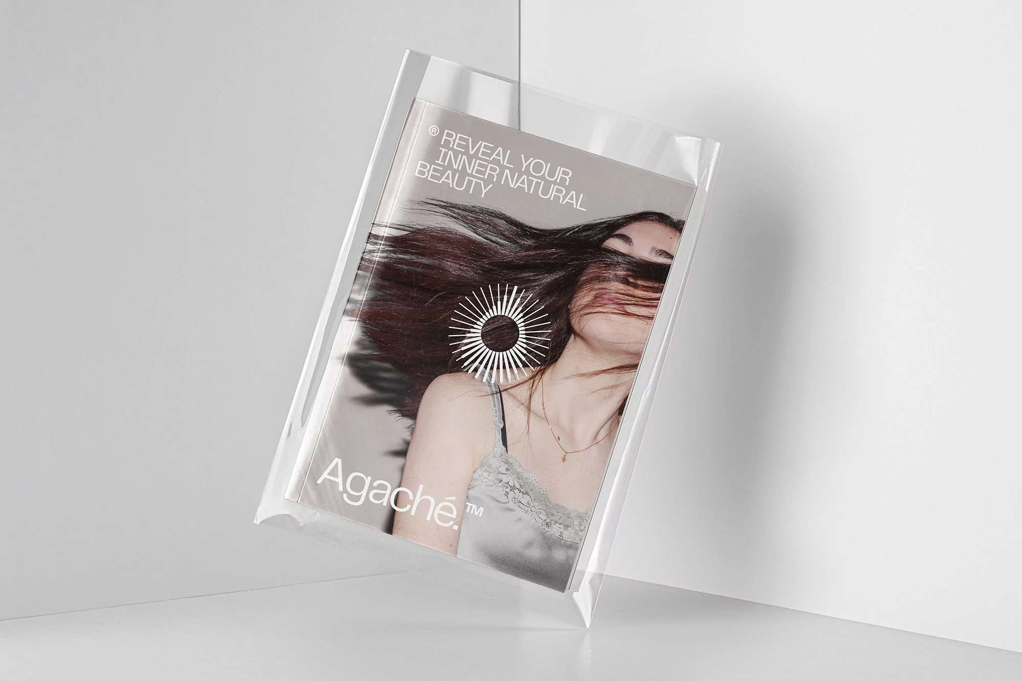 Magazine cover featuring a woman with wind-swept hair, packaged in a clear plastic sleeve, against a white corner backdrop.