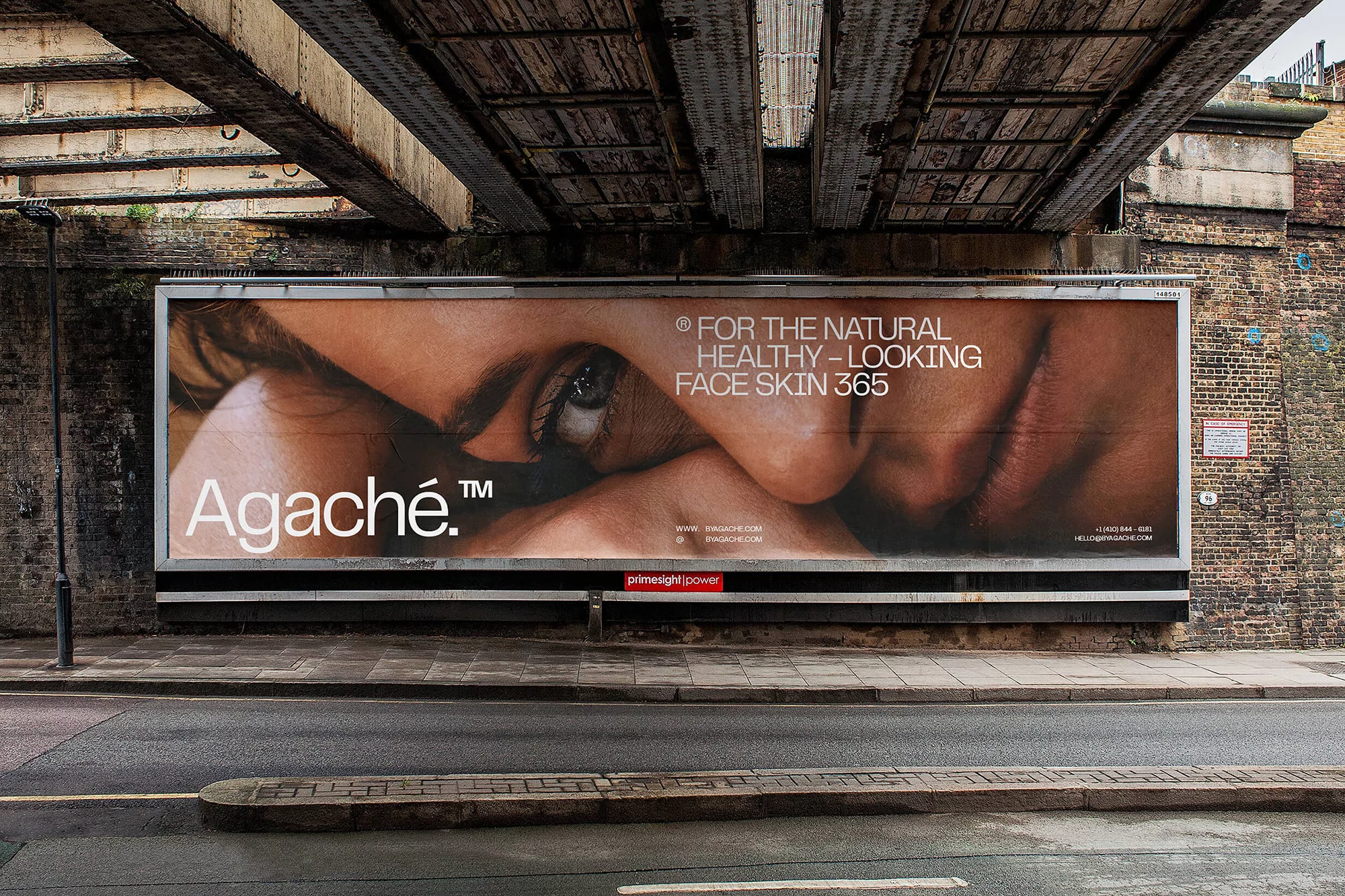 Close-up beauty ad billboard with tan skin, featuring the brand name Agache, set against an urban street and weathered underpass.