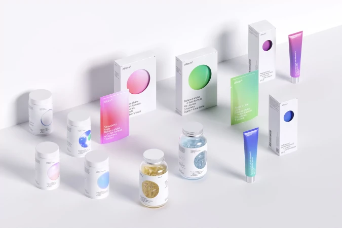 Assorted beauty and wellness product packaging in white, pink, green, and blue hues are arranged on a clean white background.