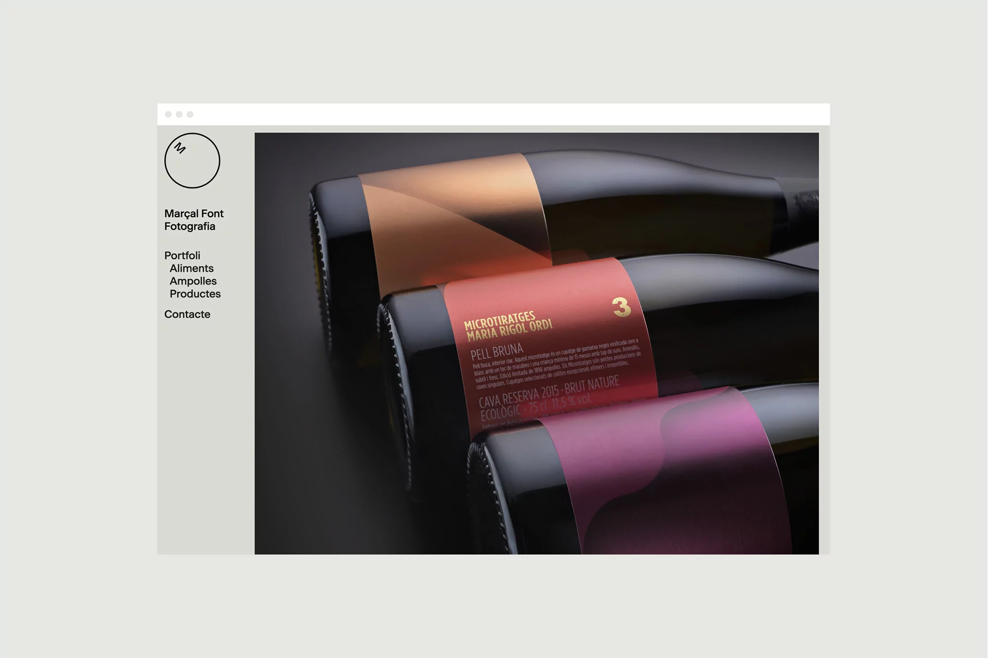 Close-up view of three wine bottles featuring colorful label designs in pink, bronze, and red tones, set against a gray background.