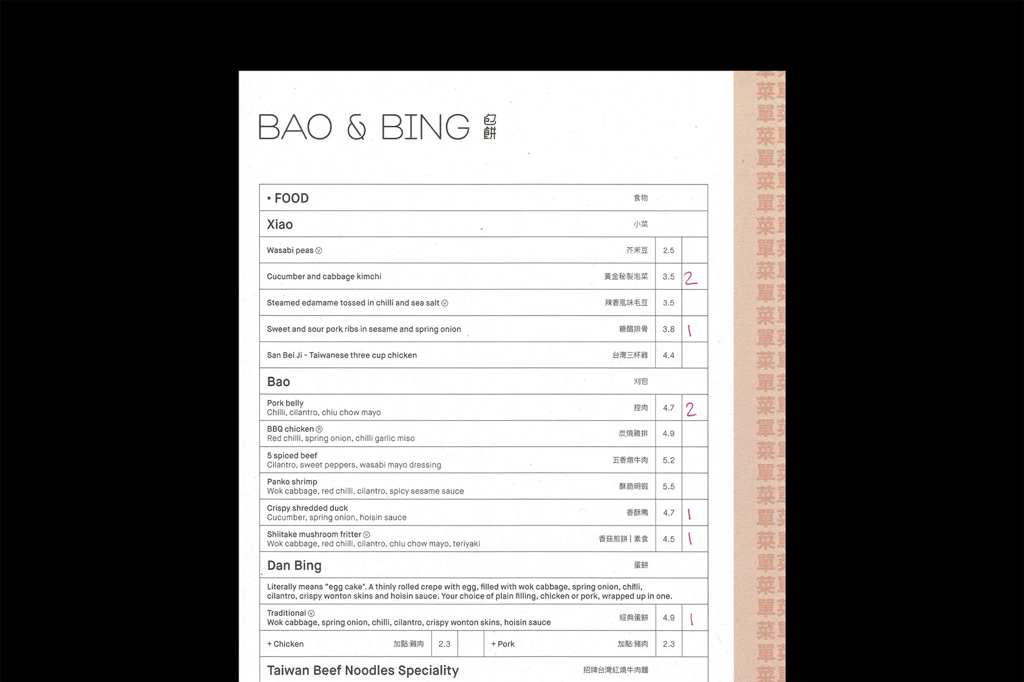 Close-up of a Bao & Bing food menu featuring a list of Asian cuisine dishes, prices, and translated text. Menu features dish descriptions.