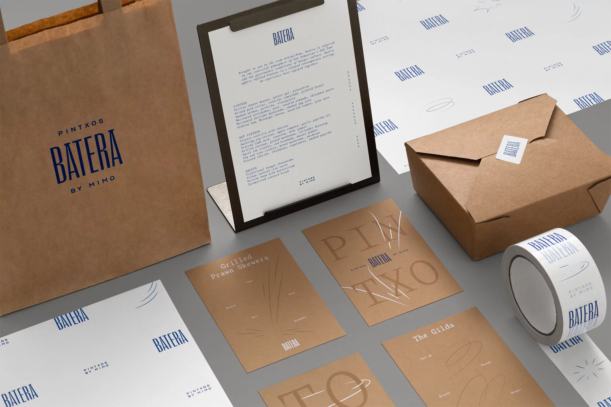 Promotional shot of takeout food packaging and menu with the 'Batera by Mimo' logo in brown and blue color scheme.