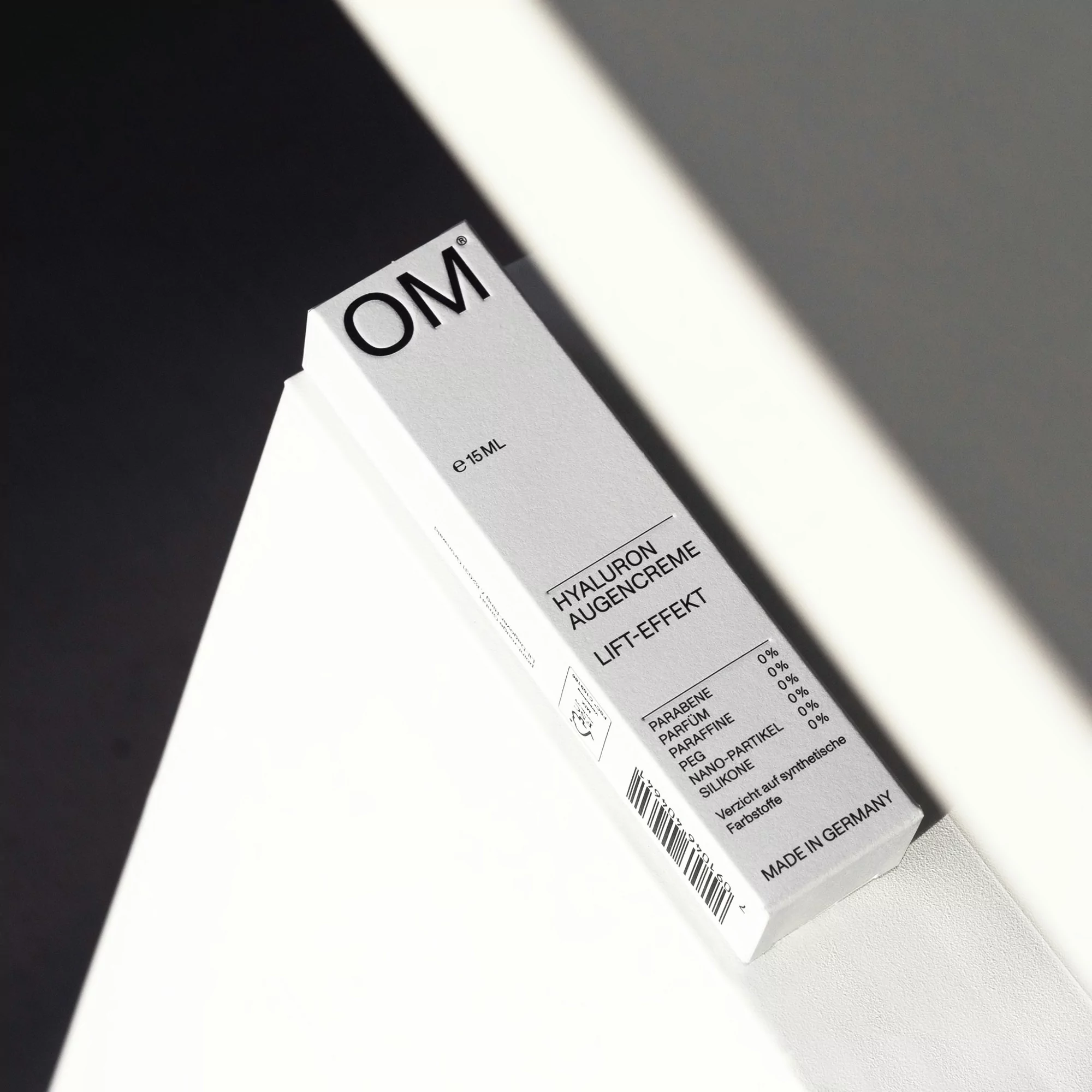 Close-up of white box of hyaluronic acid cream with black text, shadow falling across the box, studio lighting, clean presentation.