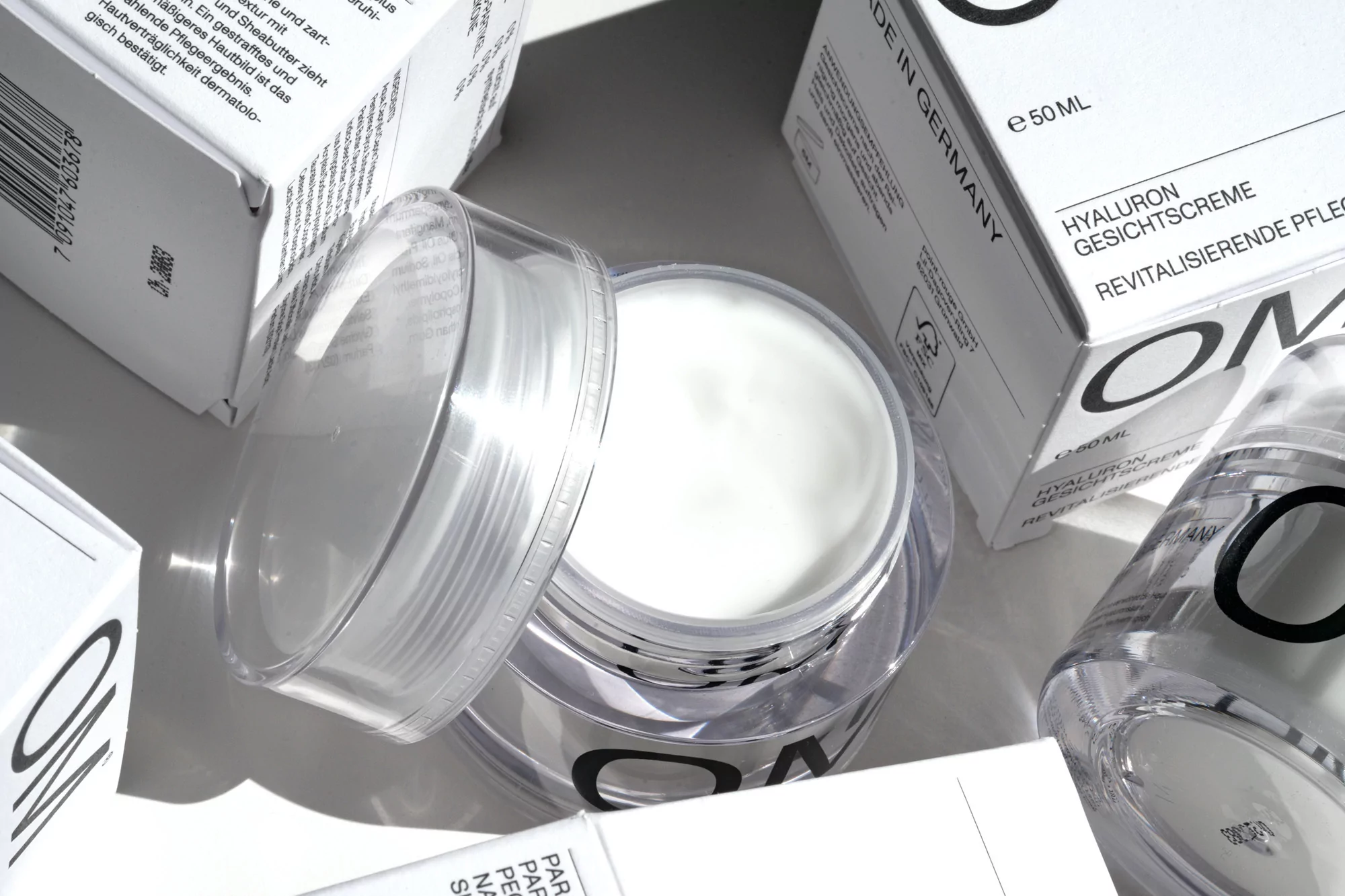 Close-up shot of a jar of skin cream with surrounding product boxes, showcasing skincare product photography.