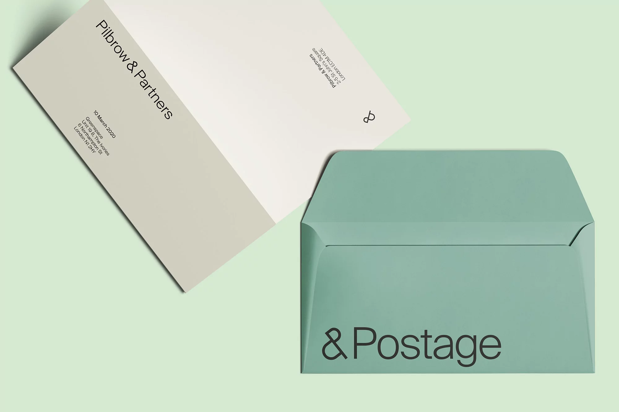 Letter and envelope stationery mockup on a light green backdrop. Design elements include text and a minimalist logo design.