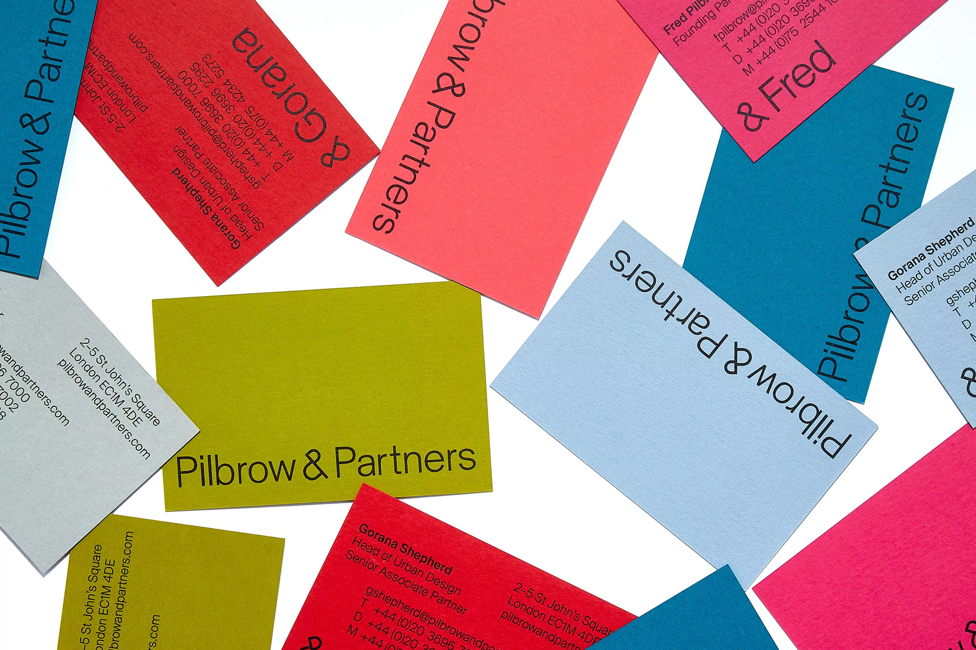 Colorful business cards featuring the Pilbrow & Partners logo, displayed on a white surface, showing vibrant colors and professional design.