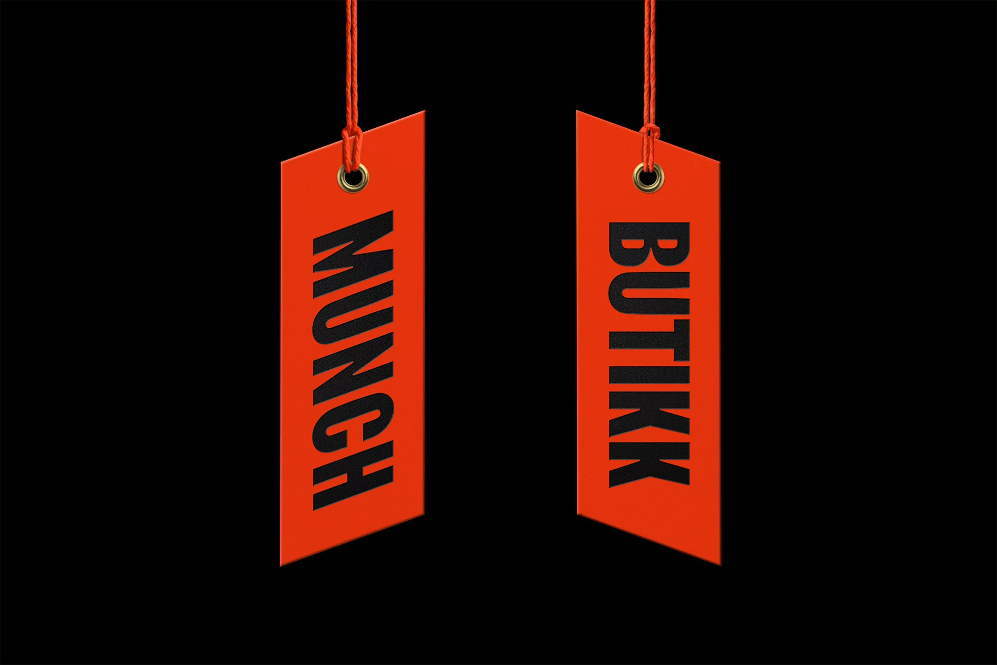 Two vibrant orange tags hang against a stark black background, each labeled 'MUNCH' and 'BUTIKK' in bold, sans-serif black text.
