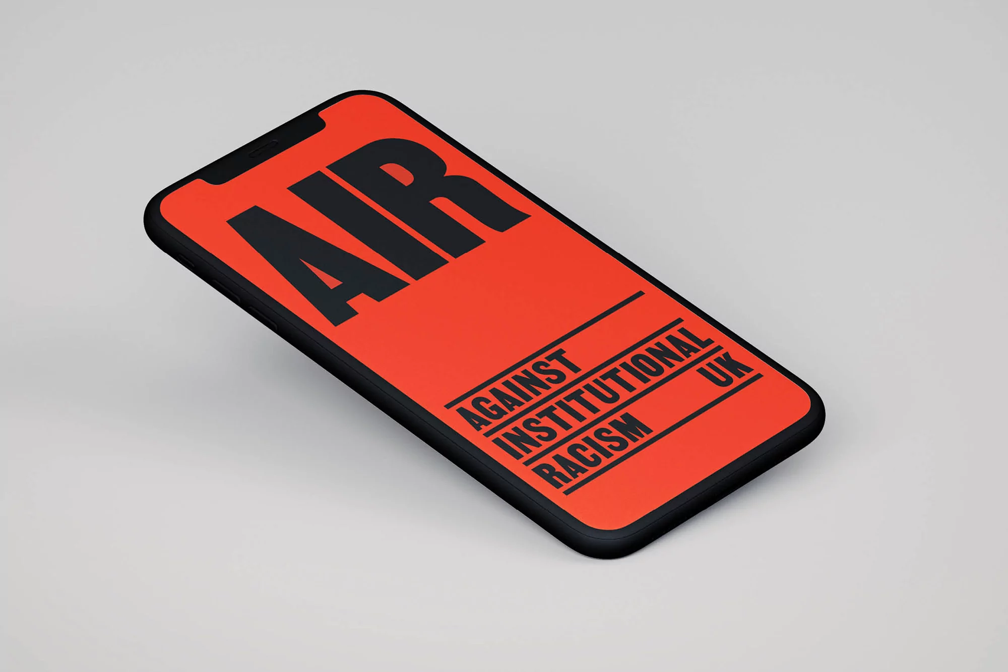 Mobile phone displaying the acronym AIR for Against Institutional Racism on an orange screen against a plain background.