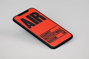 A smartphone angled on a neutral gray surface displaying a bold red and black graphic design for AIR UK brand identity.