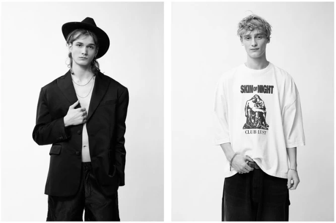 Two young adult men pose indoors against a white backdrop. The left model wears a black hat and blazer, the right wears a graphic t-shirt.