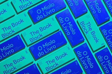 Overhead flat lay of alternating blue and turquoise rectangular book spines arranged in a repeating grid pattern