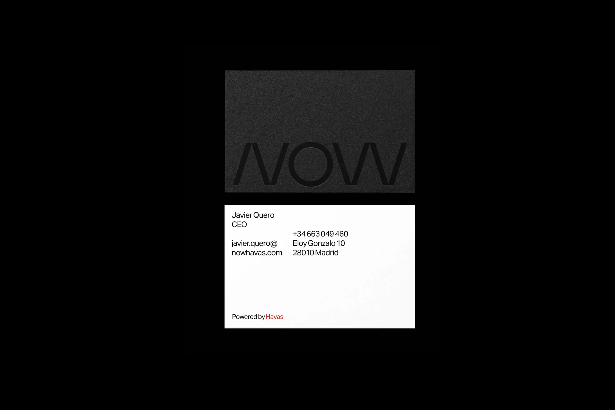 Close-up of a black business card with the embossed word 'NOW' and a white business card with company and contact information.