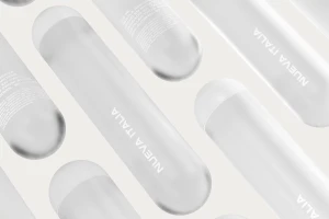 Cylindrical white product packaging arranged in a diagonal pattern featuring the text Nueva Italia against a clean backdrop.