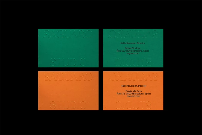 Four business cards, two in green and two in orange, are embossed with 'Saguaro Studio' and contact details on a black background.