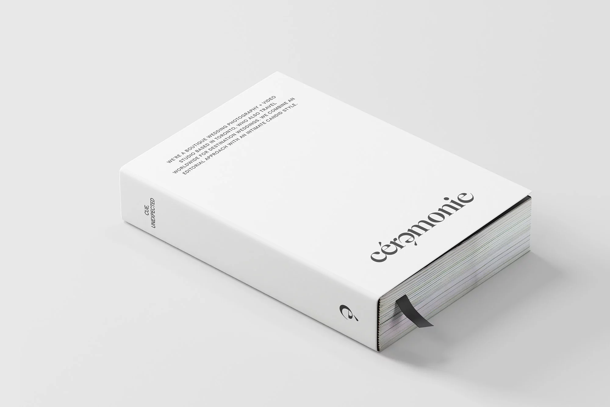 Promotional image featuring a thick, white hardcover book with black text on a light grey surface with soft shadows, minimalist design.