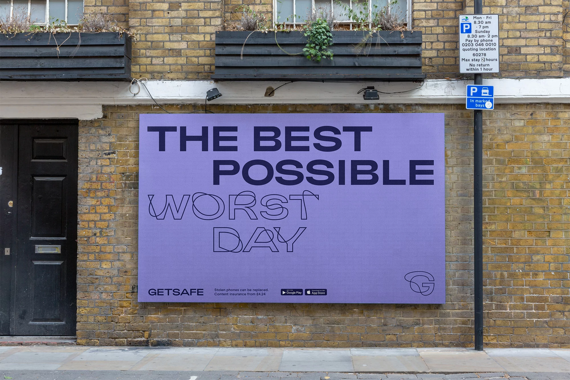 Eye-level shot of a brick wall with an advertisement for GetSafe featuring typography and the phrase 'The Best Possible Worst Day'.