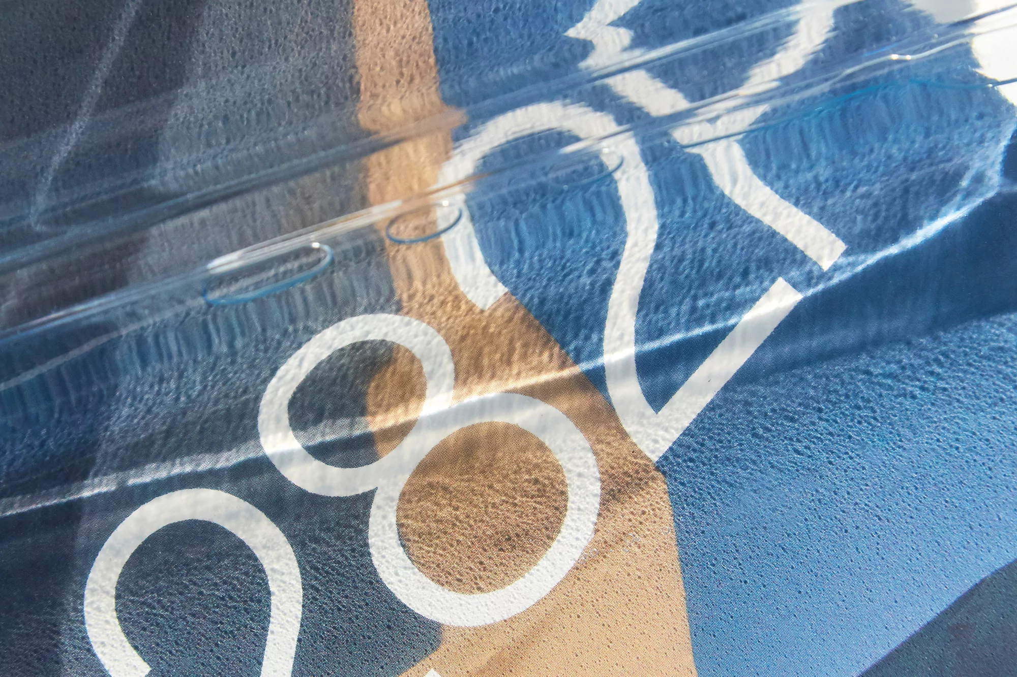 Abstract view of number '282' with light reflections over blue, brown, and white colors, creating a textured background.