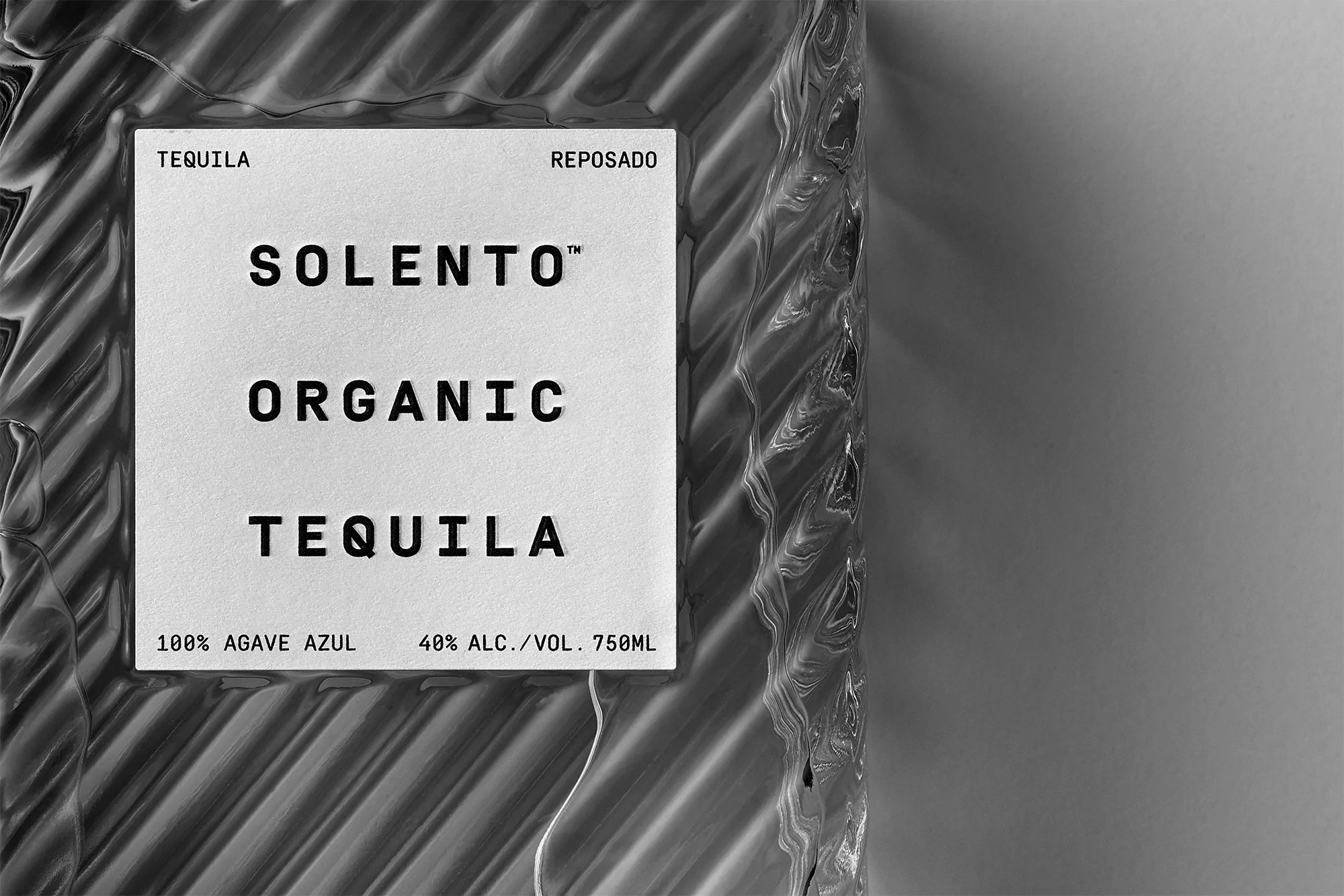 Close-up of a bottle of Solento Organic Tequila Reposado, showcasing the textured glass and minimalist label design.