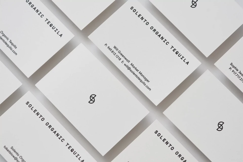 Closeup of multiple Solento Organic Tequila business cards, arranged in an overlapping grid pattern, showcasing minimalist design and brand information.