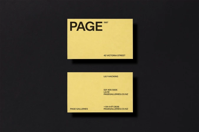 Two yellow business cards with black text, arranged on a black background. Simple design, studio shot, clean corporate aesthetic.