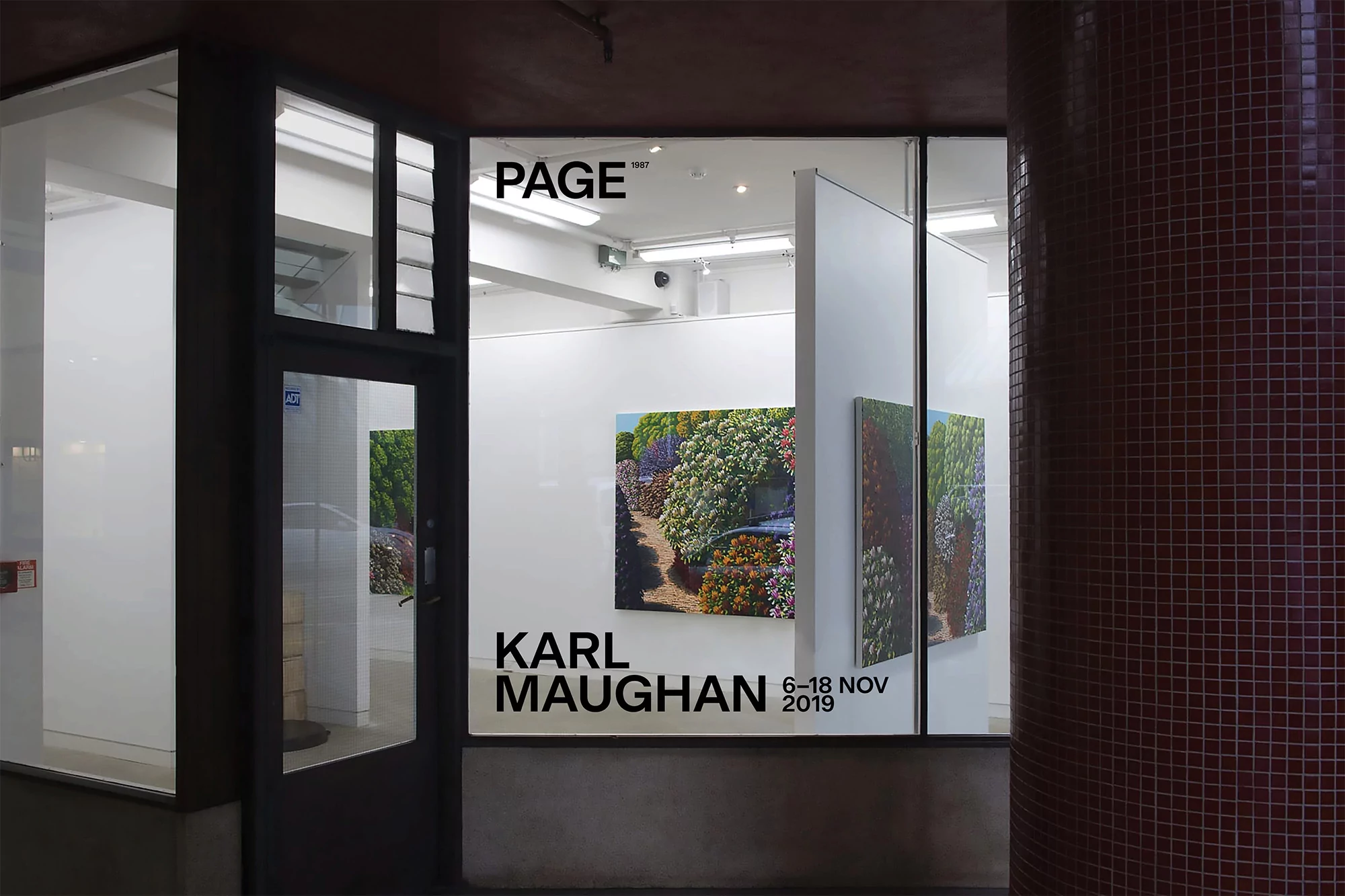 Exterior view of Page art gallery in an urban setting, featuring paintings by Karl Maughan and an exhibition advertised for November 2019.
