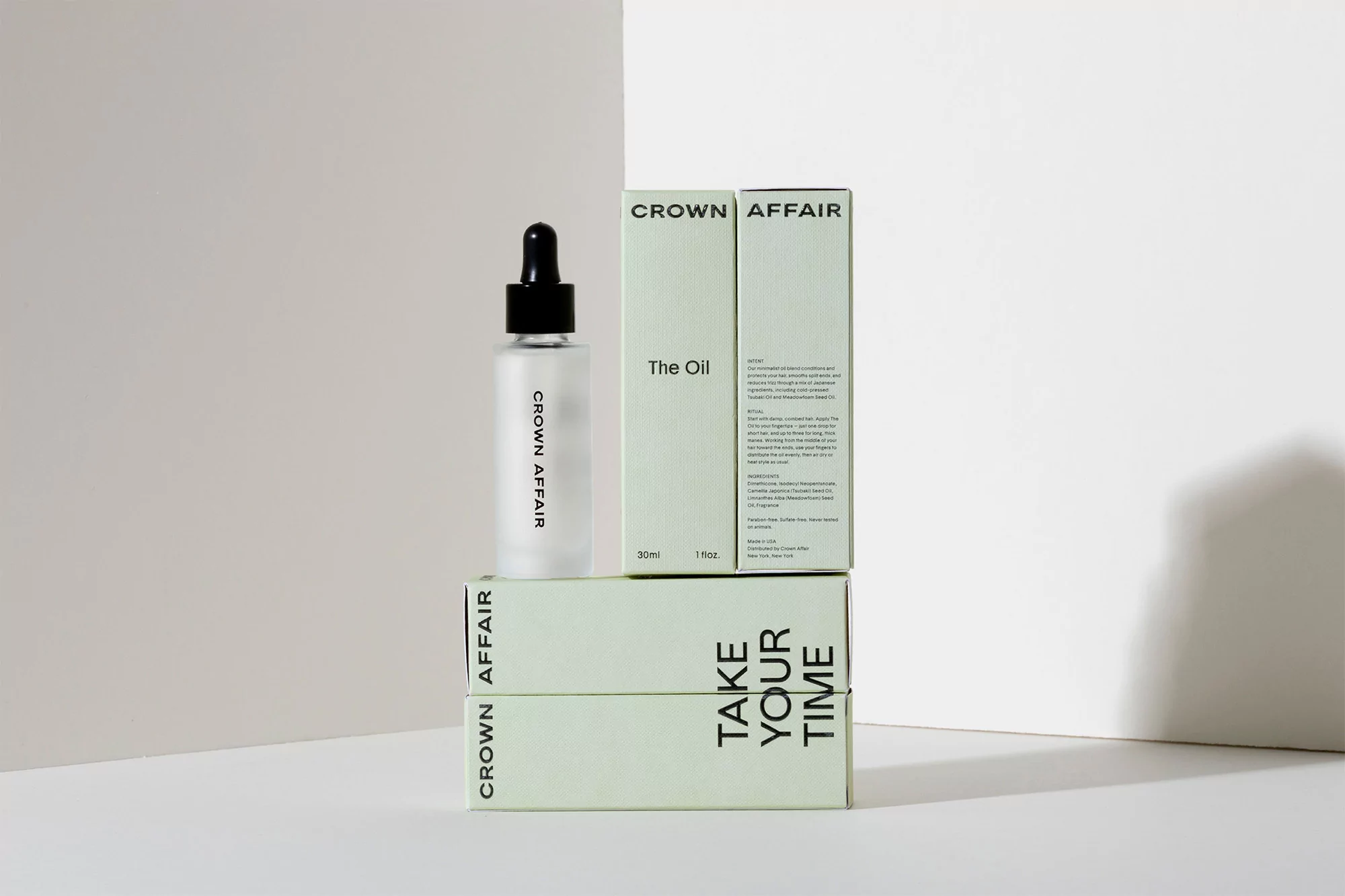 Crown Affair frosted glass bottle and product boxes in minimalist setting. Product focus for beauty, haircare, and cosmetic promotion.