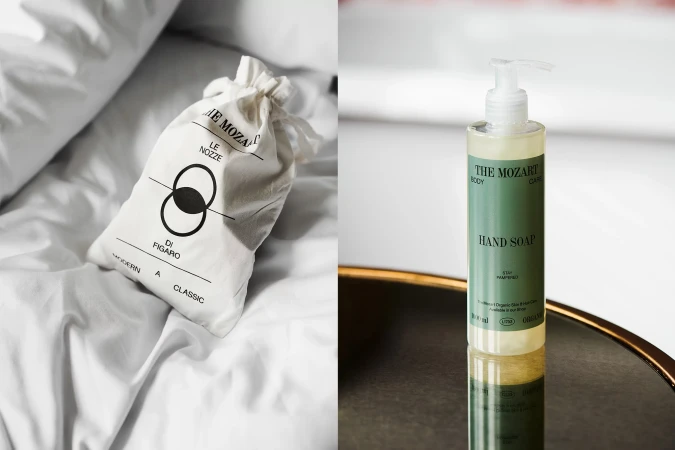 Luxury hotel amenities featuring a toiletry bag on a bed and a hand soap bottle on a reflective surface in a modern setting.