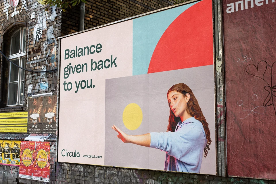 Outdoor advertising billboard featuring a woman with reddish-brown hair, promoting balance. Text: 'Balance given back to you.'