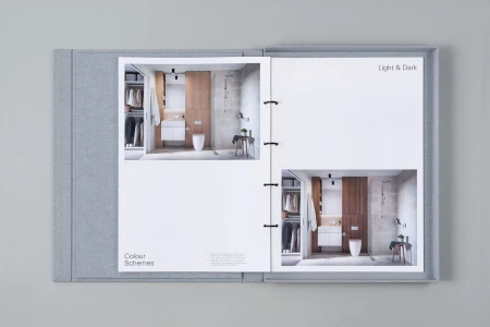Open grey fabric bound sample binder displaying interior design photography and colour scheme layouts.